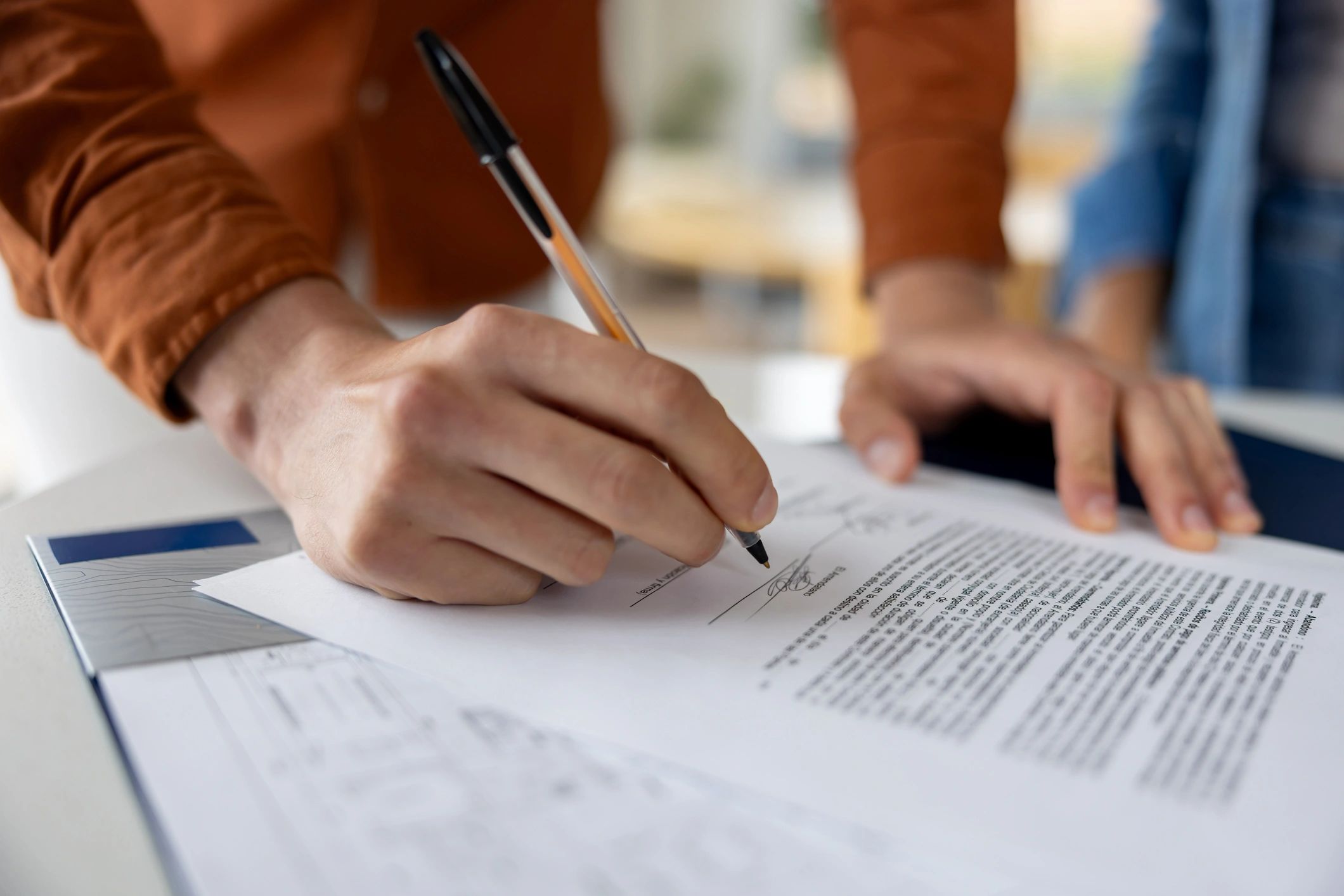 Hands reviewing and signing an archival document